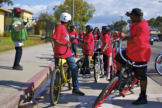 Members of the East Side Riders stop alongside Imperial Courts and offer a man a sandwich and some water. Sahra Sulaiman/LA Streetsblog