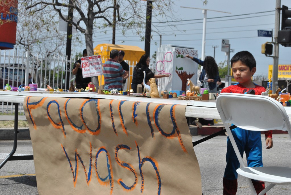 Edward Emiliano Muñoz, 4, looks at the Pacoima Wash model created by urban planner James Rojas for the Pacoima pop-up plaza event on April 19. Photo by Kris Fortin