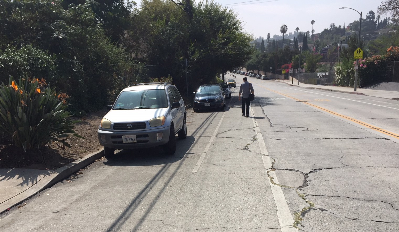 Pedestrian walking in the Griffith Park Boulevard bike lane where there is no sidewalk near Monon Street