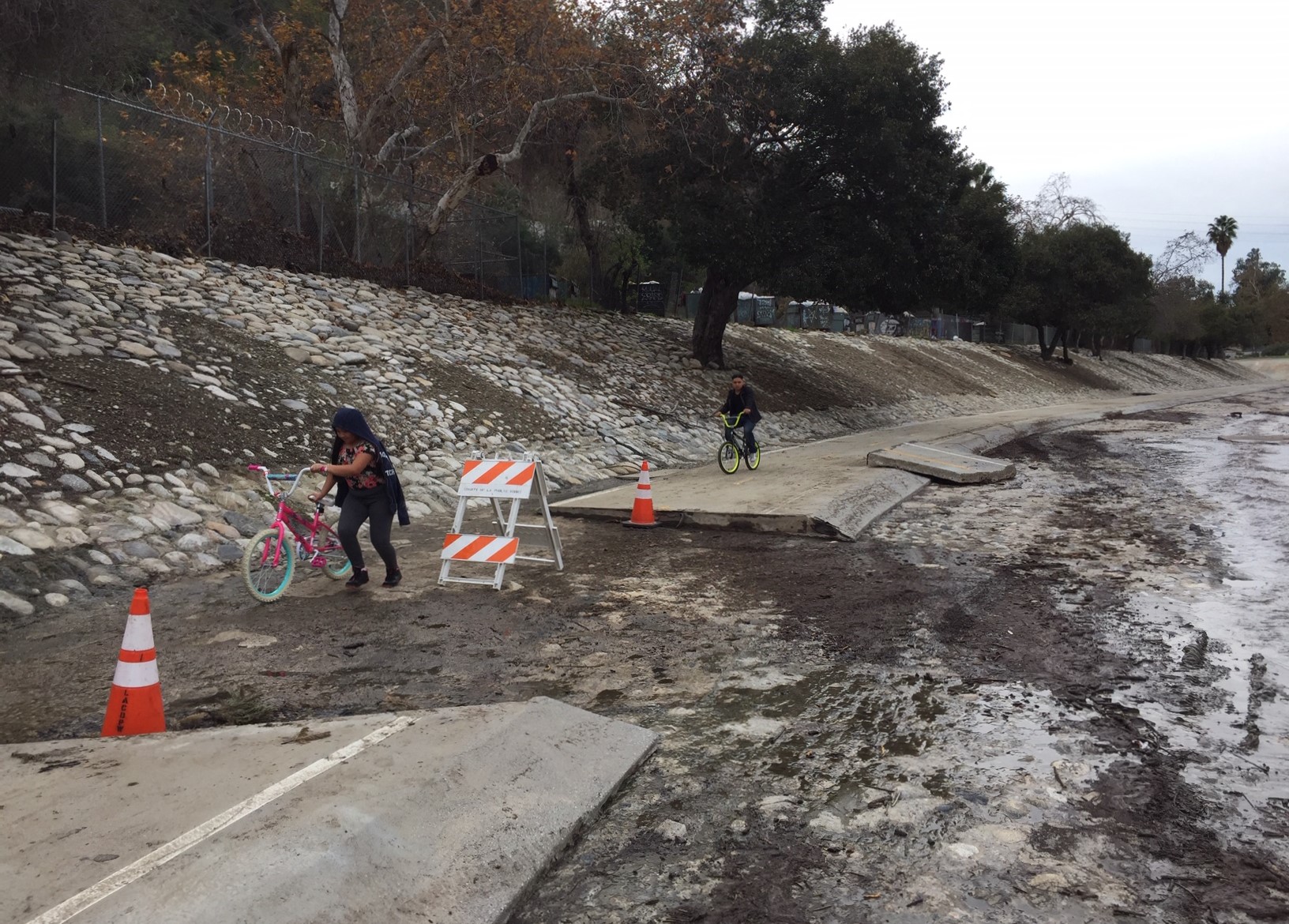 Cyclists crossing damaged area of Arroyo Seco Bike Path yesterday
