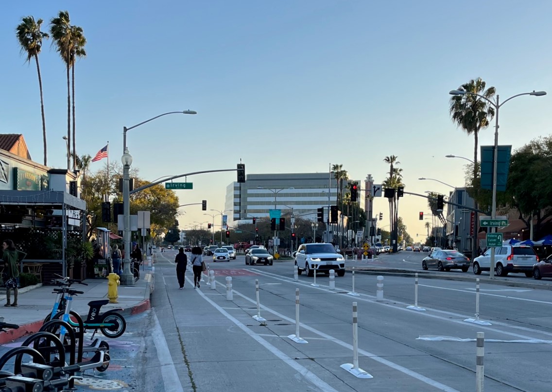 Pedestrians walk in the MoveCC protected bike lane to avoid a crowded sidewalk